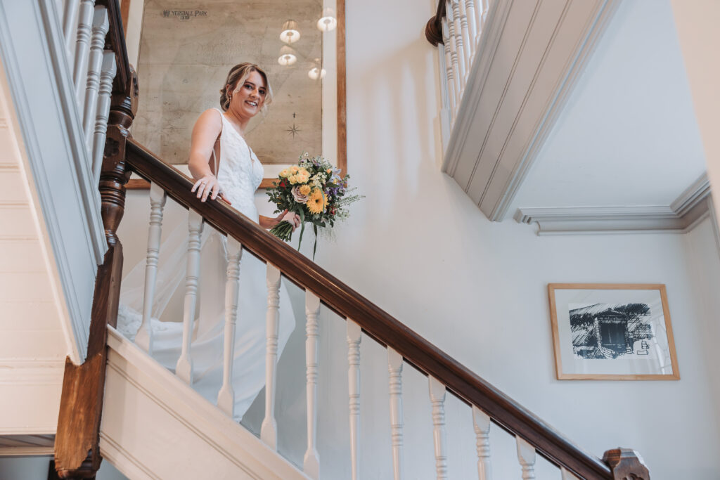 A bride walking dow the stairs at Wyresdale Park