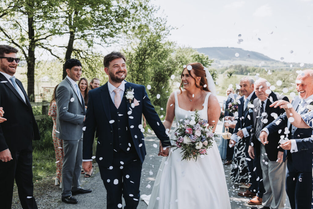 A Bride and Groom walking through confetti at Bashall Barn, Clitheroe 